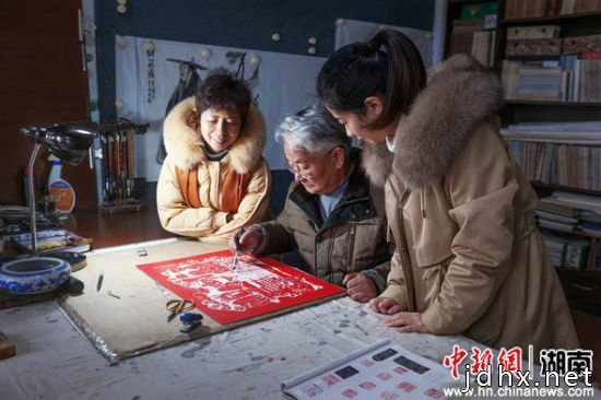 三代人创作剪纸作品。 
